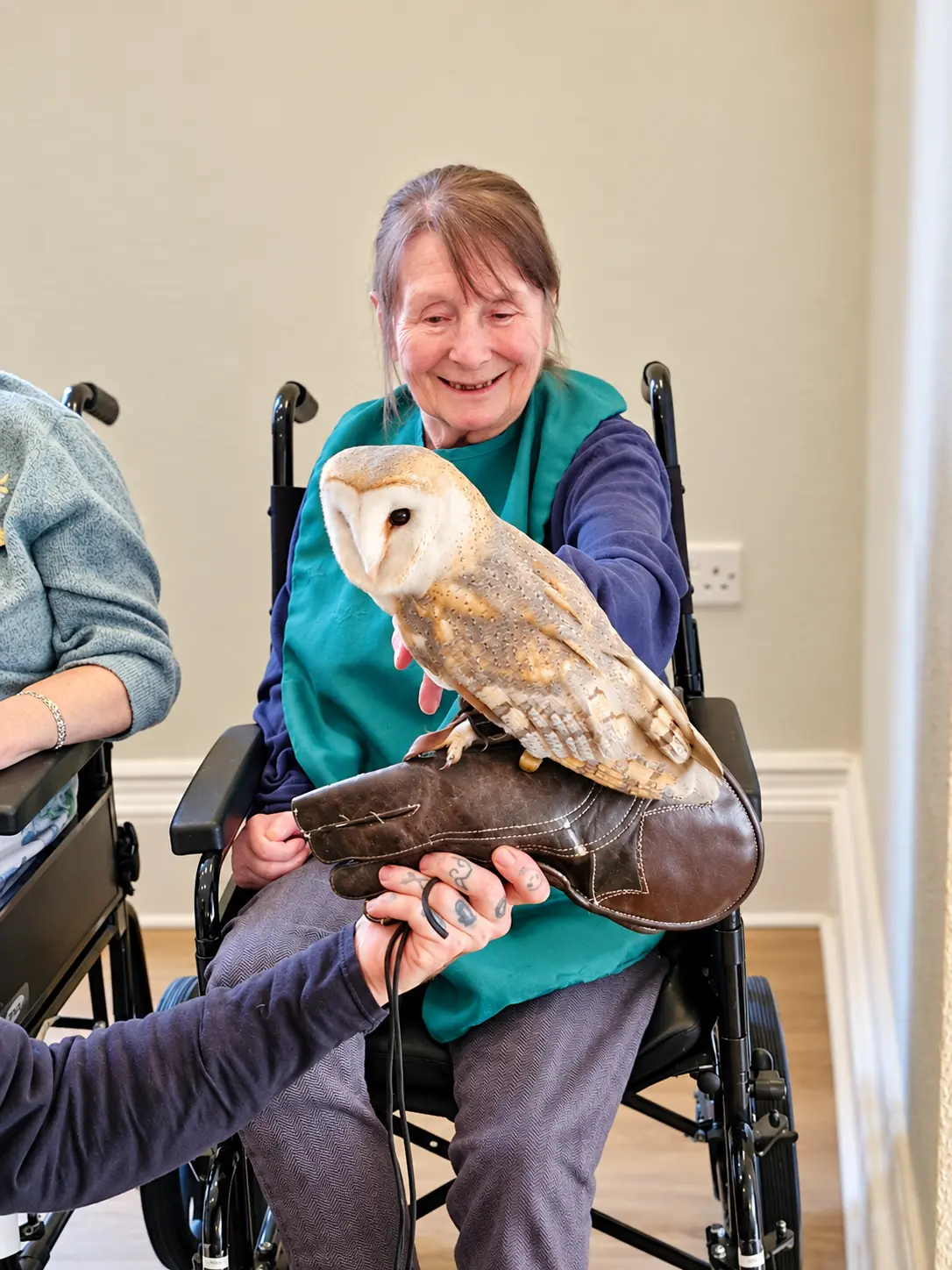 A Springfields resident smiling during a visit from a barn owl